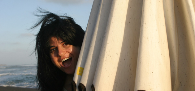 Anna Biro, professional voice actor, on the beach beside a beach umbrella